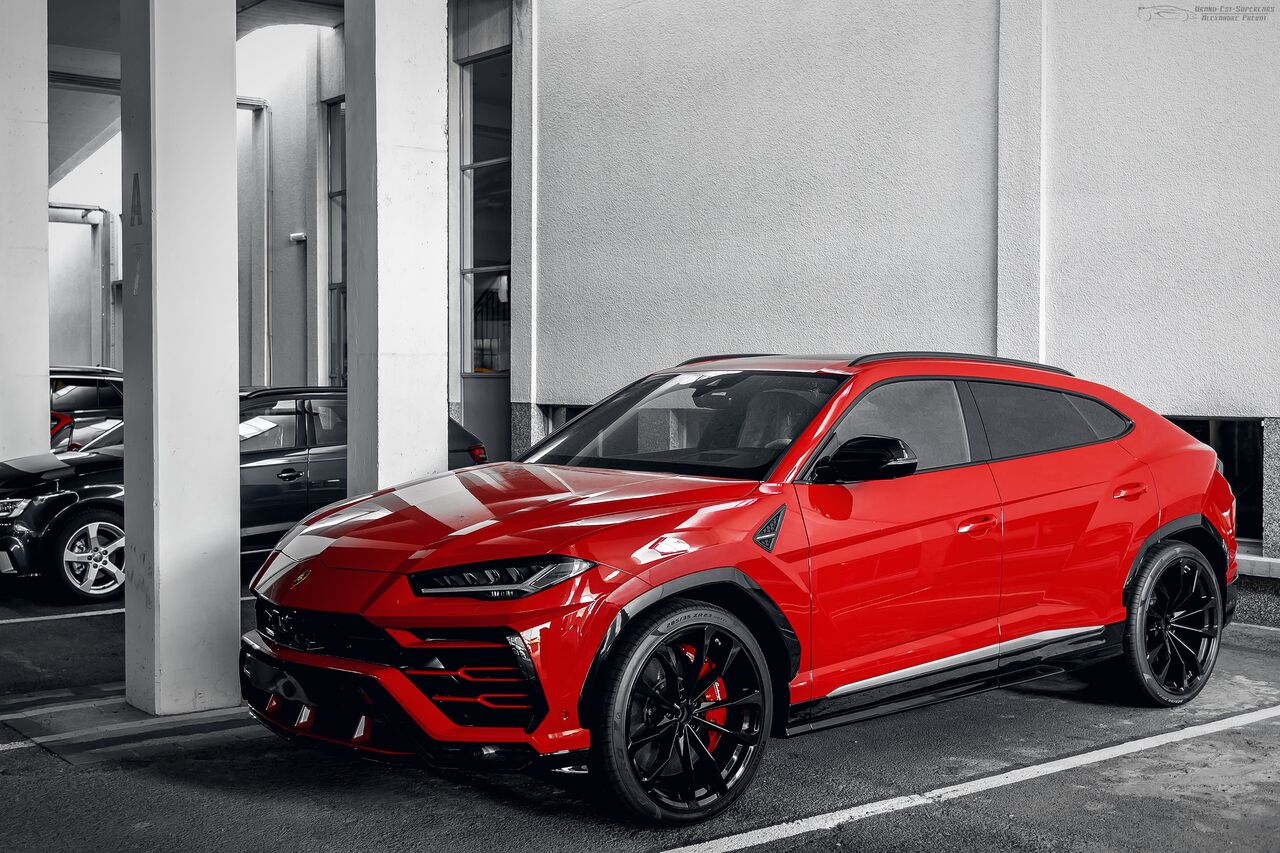 Lamborghini Urus vermelho estacionado entre colunas brancas